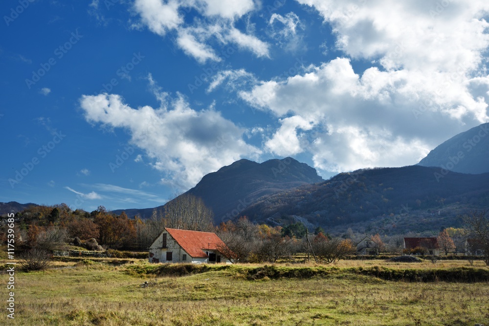 View of the valley with high hills and small wooden hous in moun