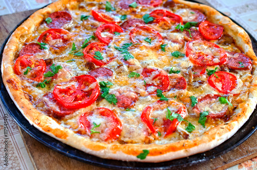 Close up of tasty pizza with chicken, tomato and cheese