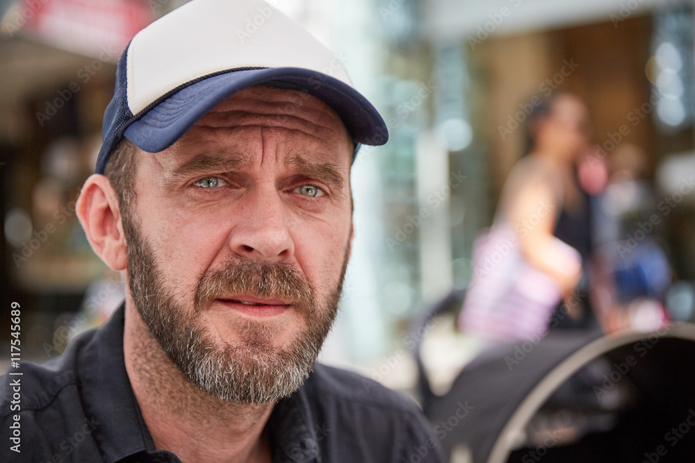 Hipster with beard and baseball cap sitting in a street cafe Hipster with beard and baseball cap sitting in a street cafe