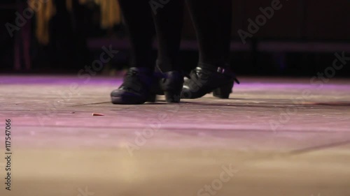 Close up of female dancing feet on stage. Women doing Irish dance with traditional step shoes. Music, tradition and culture of Ireland. Celtic show on wooden floor