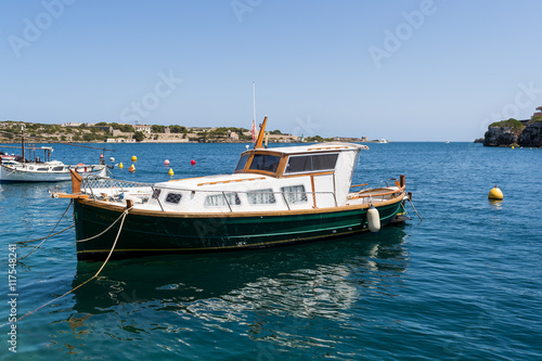 Small wooden boat floating on the sea © kithanlea