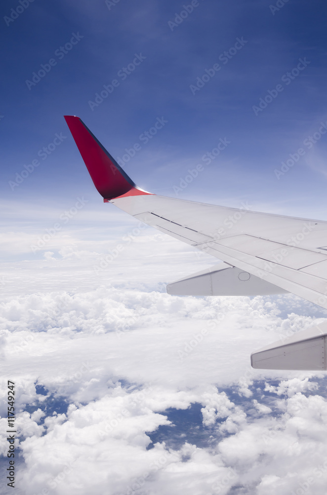 Fototapeta premium The wing of a plane flying over the sky.