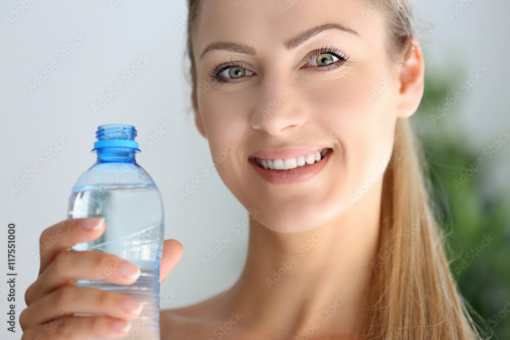 Beautiful girl drinking water on light background Beautiful girl drinking water on light background