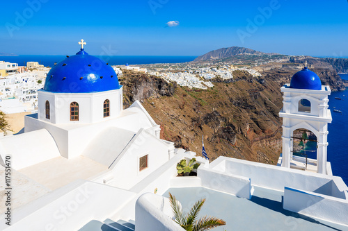 Typical Greek church in Imerovigli village with sea and volcano in background, Santorini island, Greece