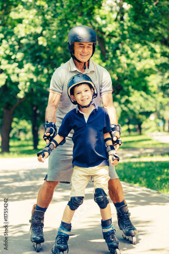 Grandfather and grandson roller skating