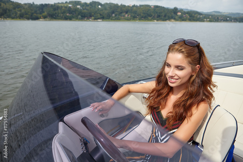 Summer vacation - young woman driving a motor boat