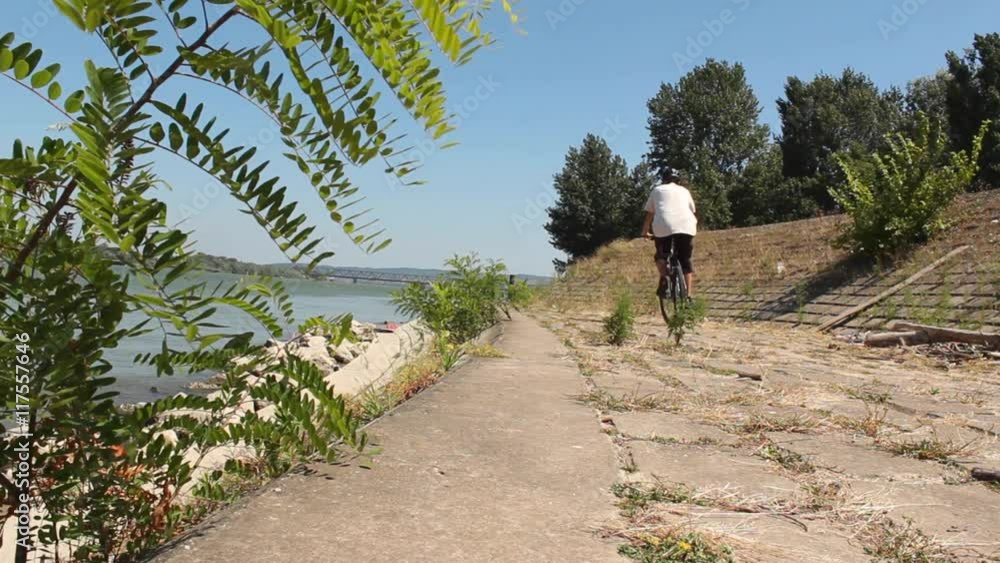 Man riding mountain bike at walkway close to Danube river at sunny summer day; Belgrade, Serbia; Man riding mountain bike at walkway close to Danube river at sunny summer day; Belgrade, Serbia;