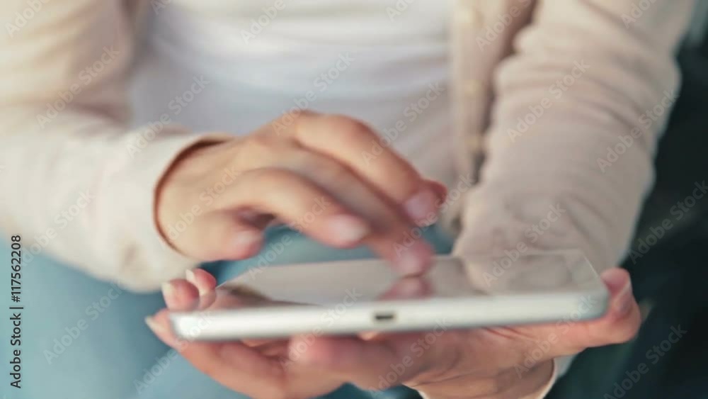 Woman using tablet on deck of cruise ship. Scrolling and touching. Sunrise light, golden hour. Close up shot of woman's hands with pad Woman using tablet on deck of cruise ship. Scrolling and touching. Sunrise light, golden hour. Close up shot of woman's hands with pad