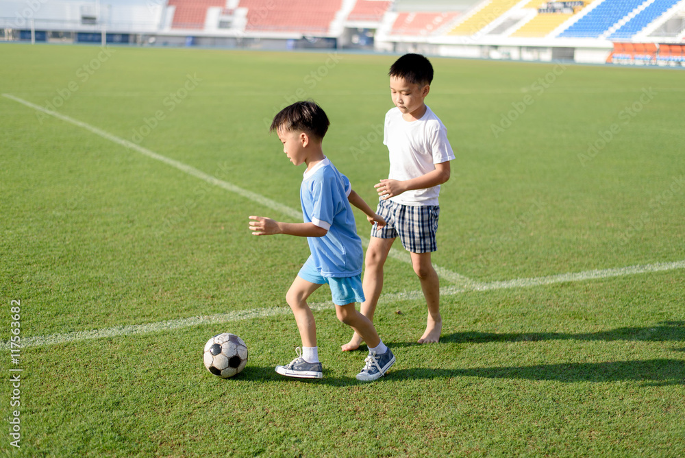 Obraz premium Boy play football on the lawn