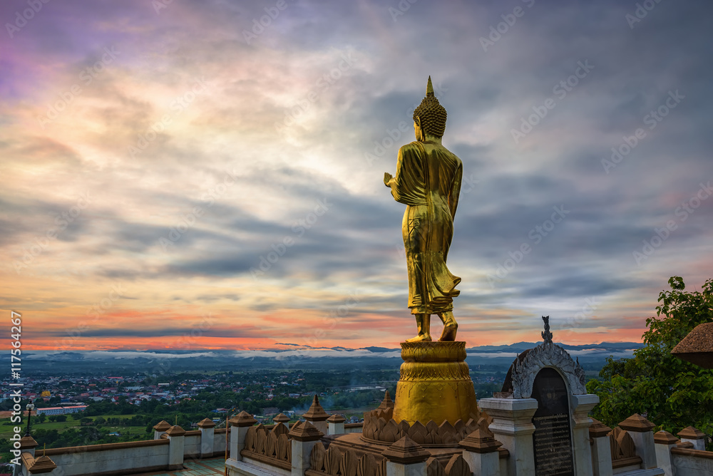 Buddha standing on a mountain at morning Wat Phra That Khao Noi,