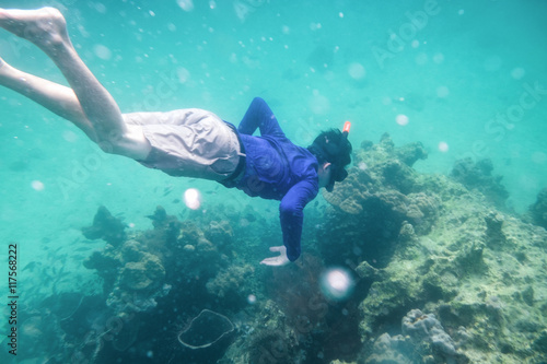 Man diving in emerald andaman sea on coral reef