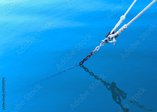 Photo Anchored boat, rope in thew water