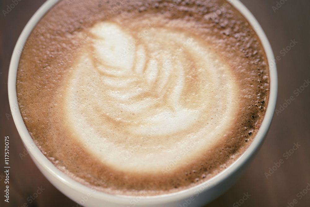 cup of cappuccino on wood table with latte art cup of cappuccino on wood table with latte art