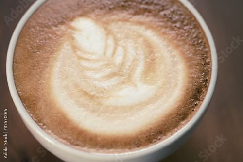 cup of cappuccino on wood table with latte art