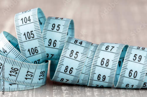 Measuring tape on grey wooden background