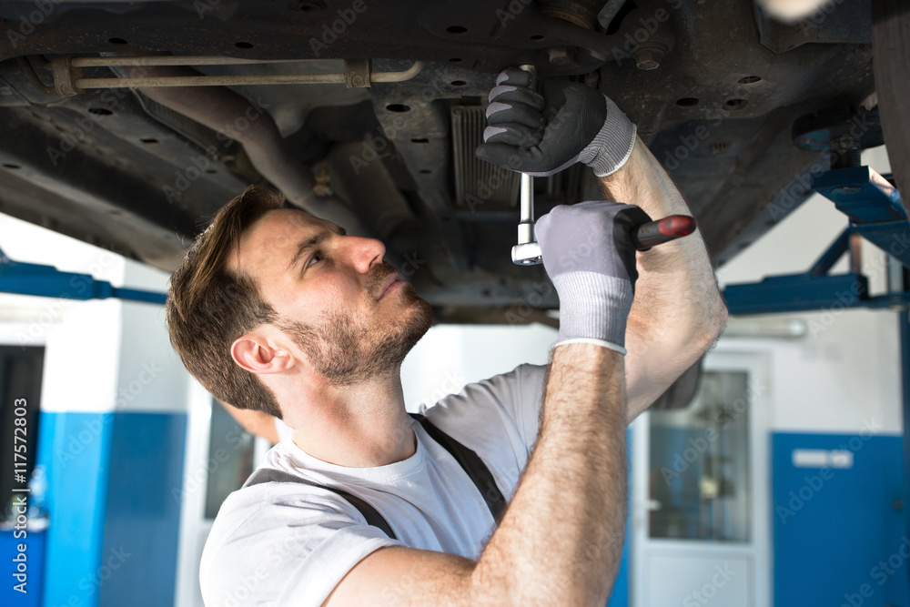 Mechanic with a tool under the car Mechanic with a tool under the car