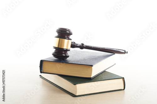 Law concept - Book with wooden judges gavel on table in a courtroom or enforcement office.