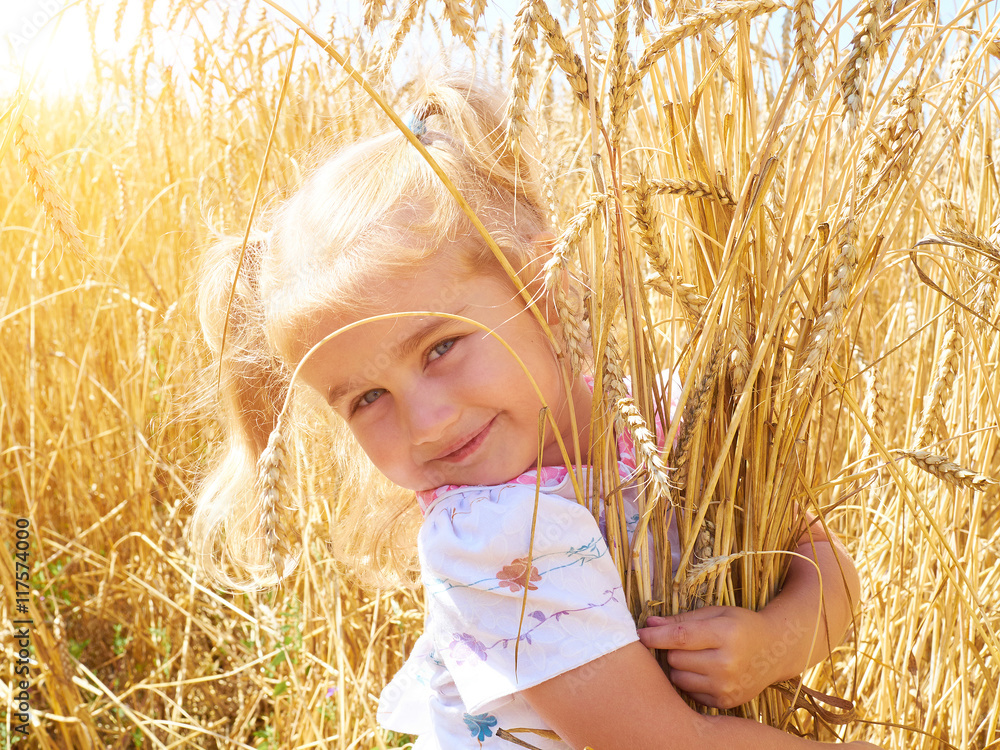 Cute little girl playing in the summer field of wheat Cute little girl playing in the summer field of wheat
