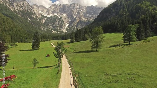 Camera flying above road pathway to the mountains with breath taking view