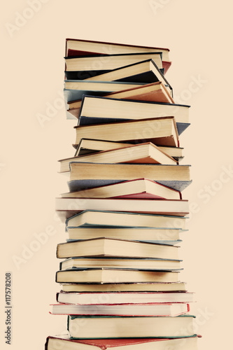 High stack of books on light background