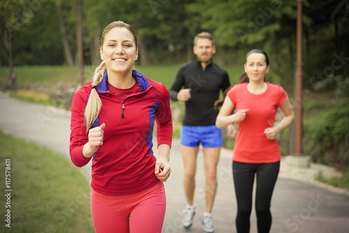 Smiling friends running outdoors. 