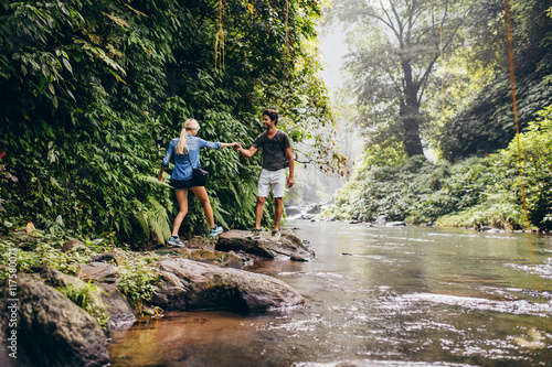 Couple walking by stream in forest