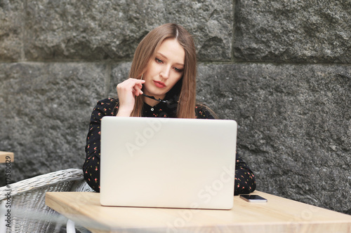 Business women wearing  black shirt in the cafe is looking into laptop © hannakatanska