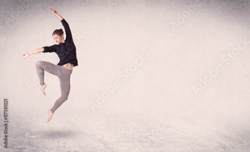 Modern ballet dancer performing art jump with empty background