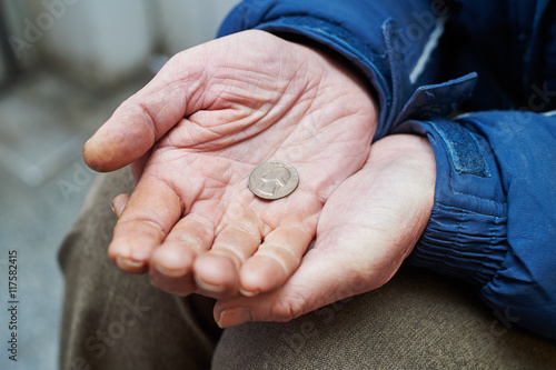 hands of beggar with us cent coin begging for money  photo