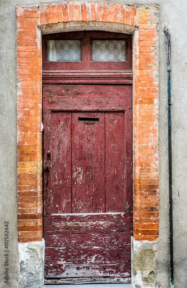 old vintage decaying wooden door facade with brick wall frame