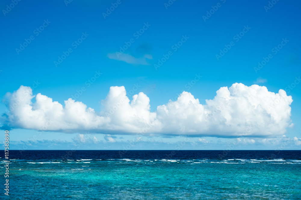 沖縄の透き通った海に浮かぶ長い雲