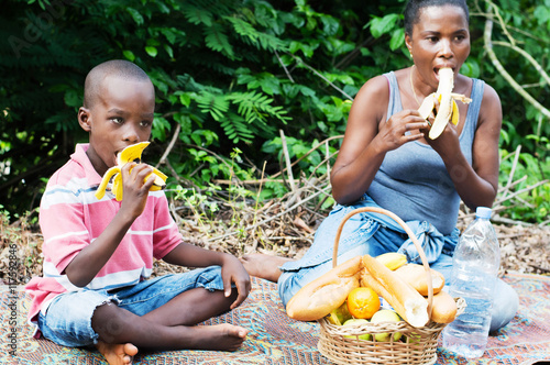 young woman and her son eat bananas during a relaxing out