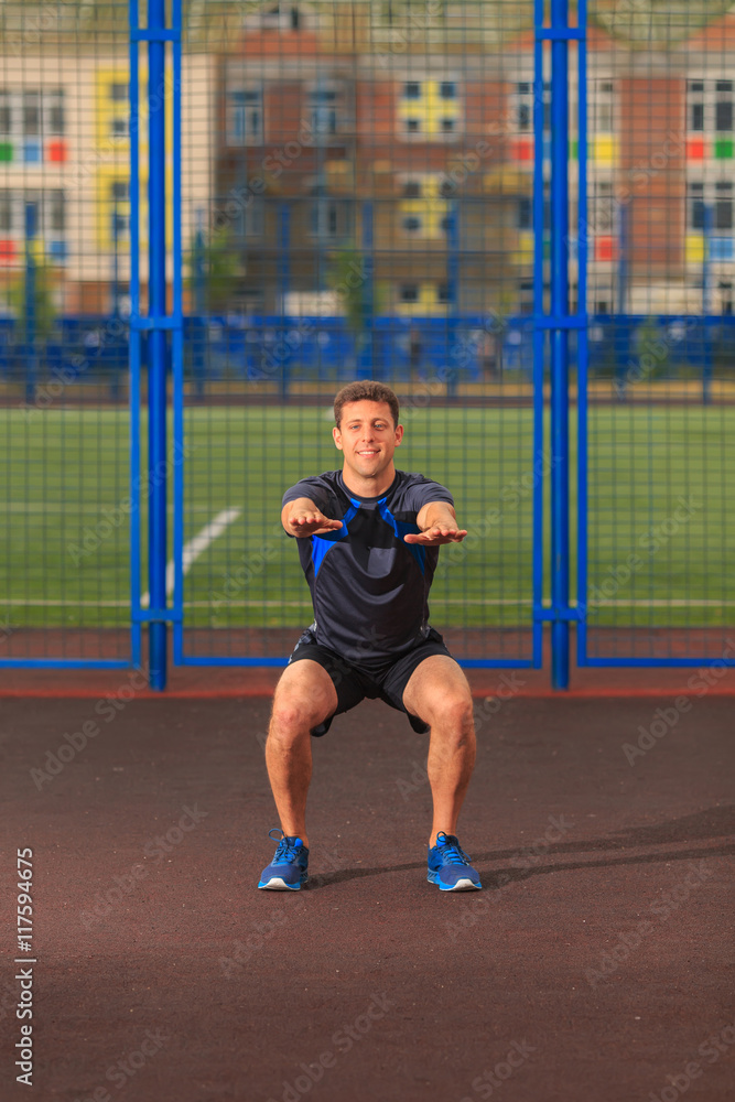 young man doing exercises at the stadium