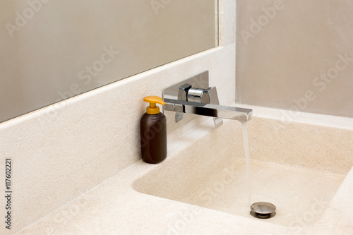 batroom sink with running water photo