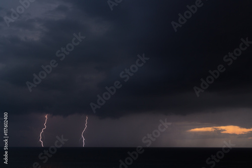 Lightning storm over the sea during sunset