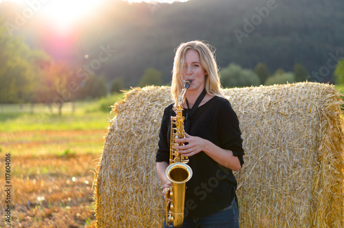 Obraz na plátně Female musician playing a tenor saxophone