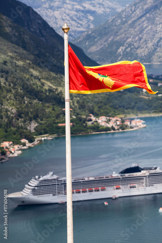 Montenegrin national flag on background of cruiseferry in Gulf of Kotor (Boka Kotorska), Montenegro
