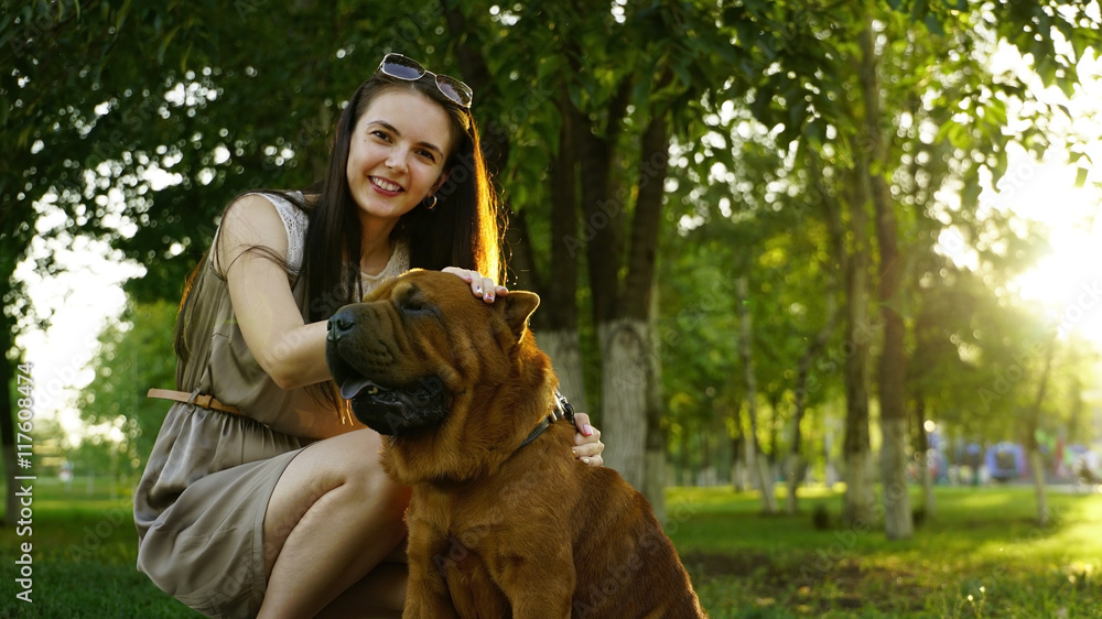young woman walking in the park with a Shar-Pei young woman walking in the park with a Shar-Pei