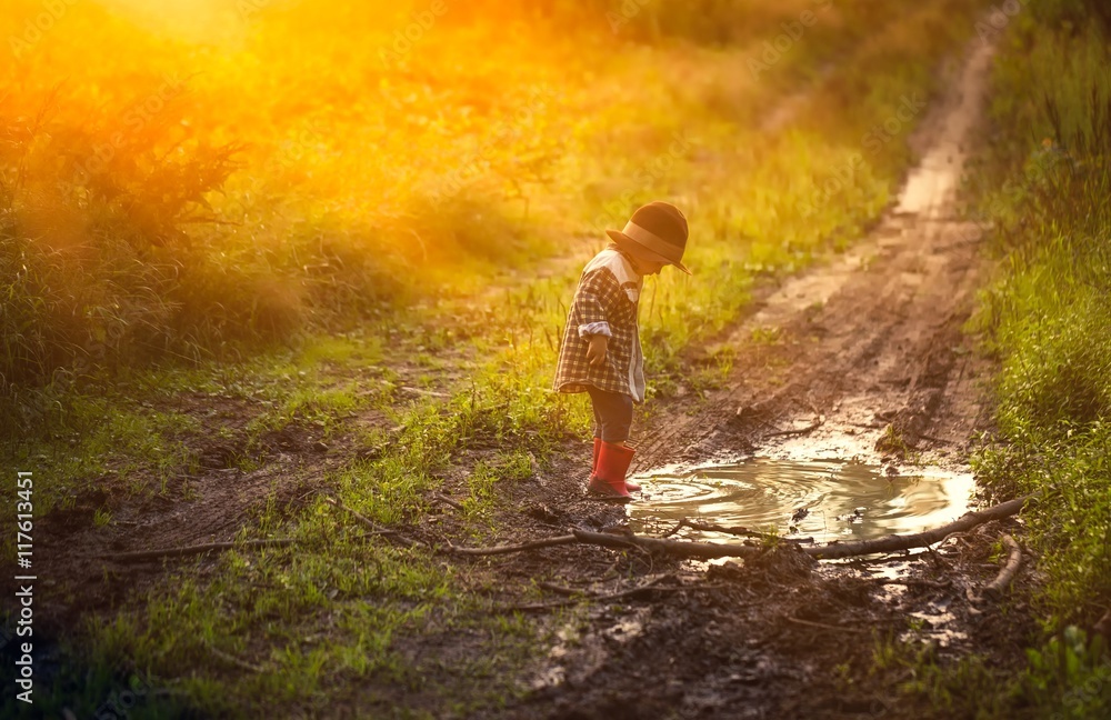 Obraz premium Boy playing in puddle in forest