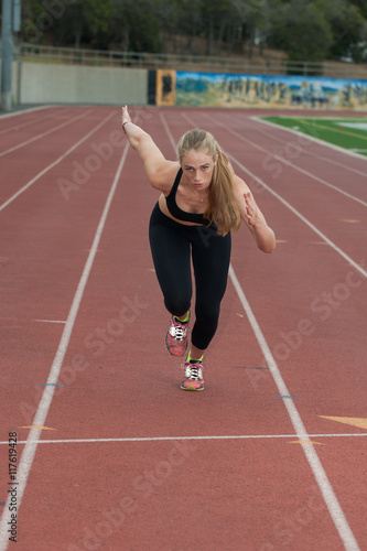 Blond female runner in black tights at full speed. 