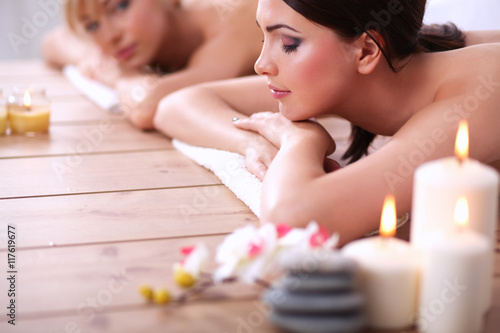 Two young beautiful women relaxing and enjoying at the spa center