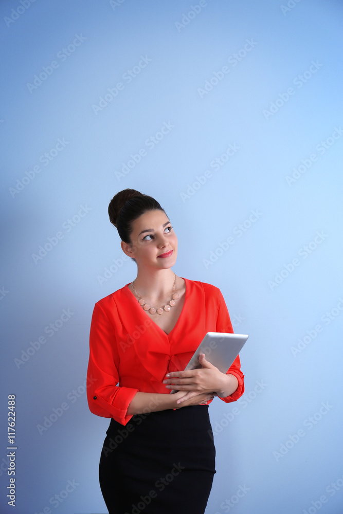 Pretty young woman holding tablet on light background Pretty young woman holding tablet on light background