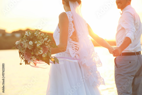 Groom and bride on sunset background