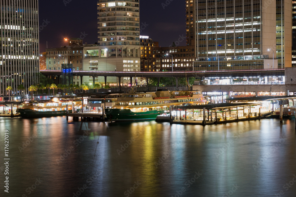 Circular Quay railway, train station and ferry wharfs with Sydney Central Business District, downtown skyscrapers at the background. Cityscape night shot, long exposure, copy space Circular Quay railway, train station and ferry wharfs with Sydney Central Business District, downtown skyscrapers at the background. Cityscape night shot, long exposure, copy space