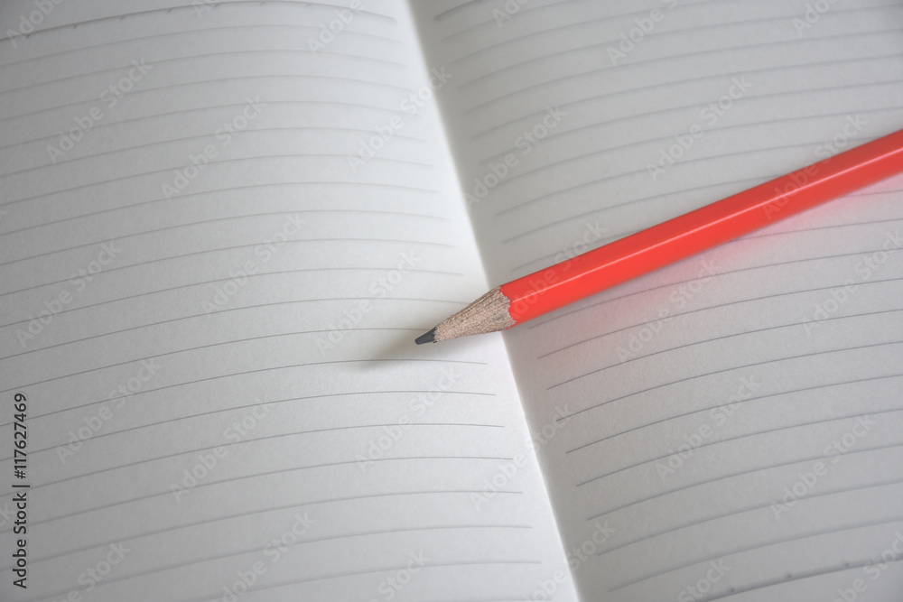 A white note book with lots of room for your text or image and a regular pencil on a wooden desk A white note book with lots of room for your text or image and a regular pencil on a wooden desk