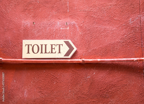 toilet plate signage on red wall texture