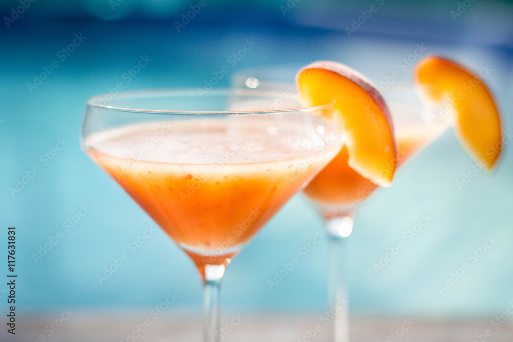 Bellini cocktail with peach isolated near pool