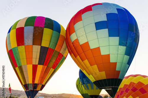 Colorful hot air balloons flying in the sky in Italy.