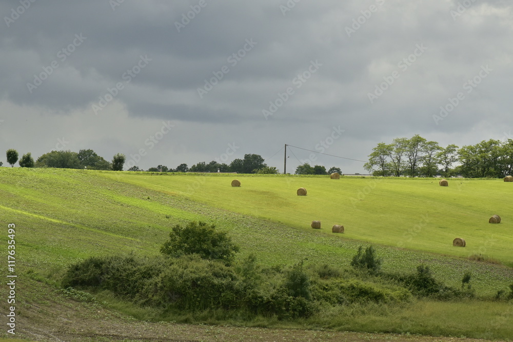 Champs de blé et bottes de foin avant le passage d'une forte averse au Périgord Vert