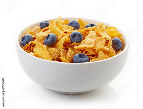 Bowl of corn flakes and blueberries isolated on white